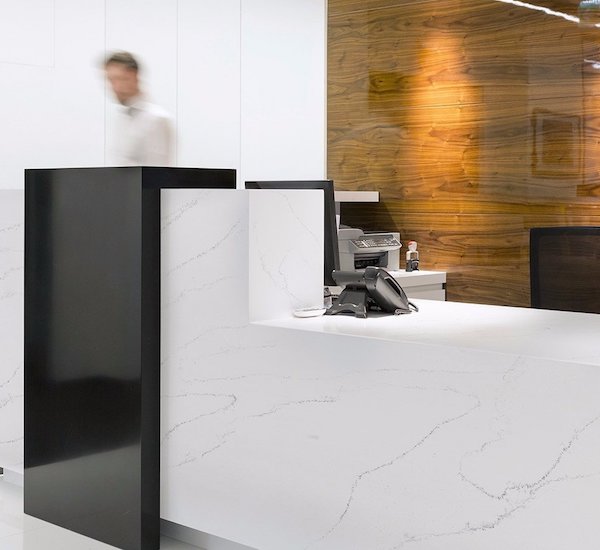 HanStone Quartz Tranquility white quartz counter top surface with charcoal vein on reception desk
